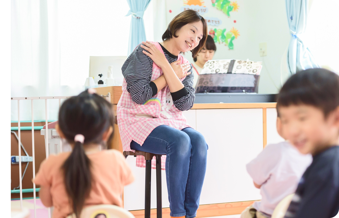 子どもたちと一緒に歌を歌う先生